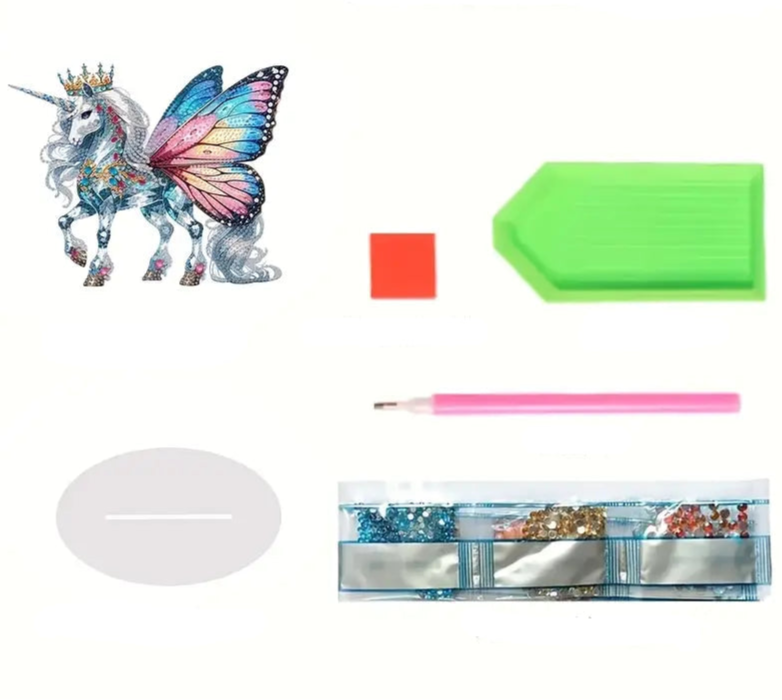 Diamond paint ornament på fod af hvid enhjørning med flerfarvede sommerfuglevinger og krone på. 
Samt medfølgende udstyr.