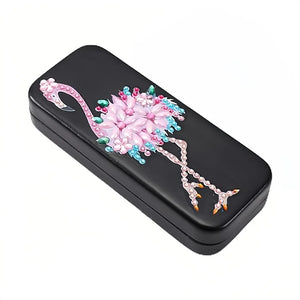 Etui til briller dekoreret med en farverig pink flamingo på sort baggrund.