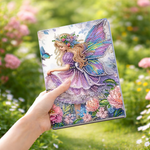 Diamond painting notesbog med en fe i lilla kjole omgivet af blomster.