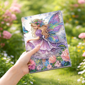 Diamond painting notesbog med en fe i lilla kjole omgivet af blomster.