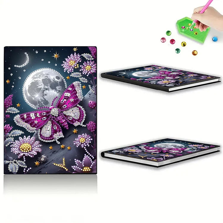 Diamond painting notesbog med lilla sommerfugl omgivet af blomster og fuldmåne. DIY-projekt