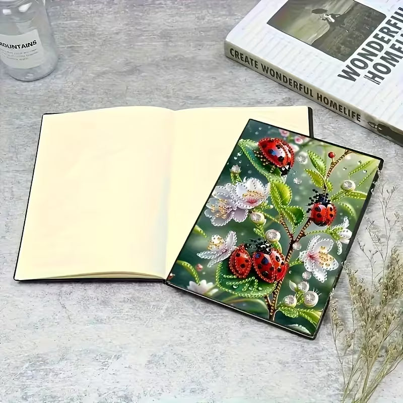 Notesbog med blanke sider. Mariehøns på forsiden dekoreret med diamond painting.