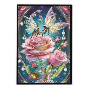 Diamond painting notesbog med lyserøde roser og insekter.