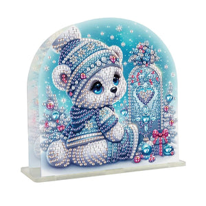 Diamond paint servietholder med en lille hvid bamse med blå hue omgivet af julepynt og pakker.