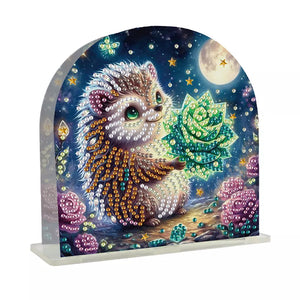 Servietholder i akryl med et lille pindsvin der holder en grøn blomst.